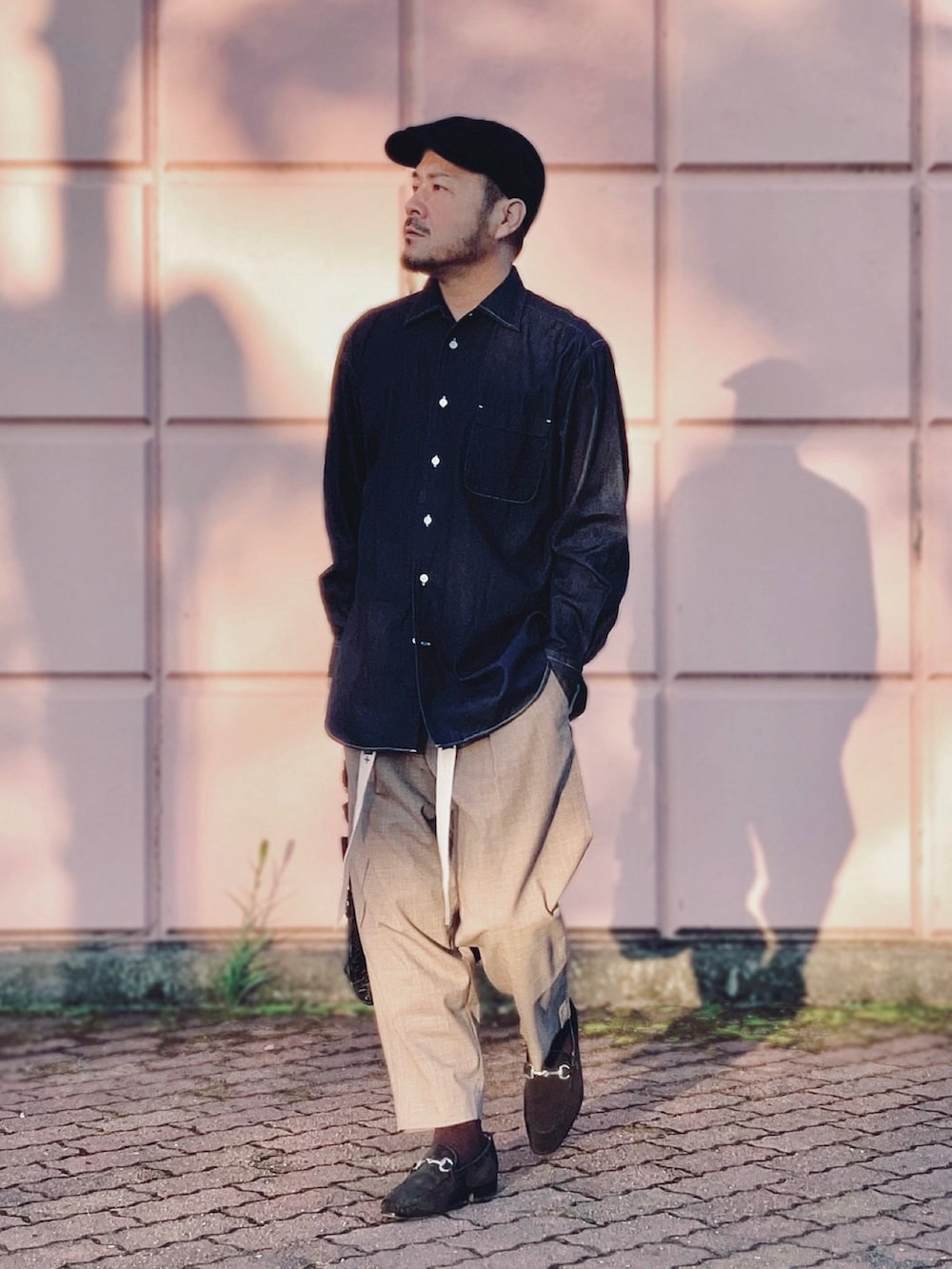 ブラウン系のスラックス、ブラック系のローファー、ブラック系のトートバッグを着用したメンズの秋コーディネートの4枚目の写真