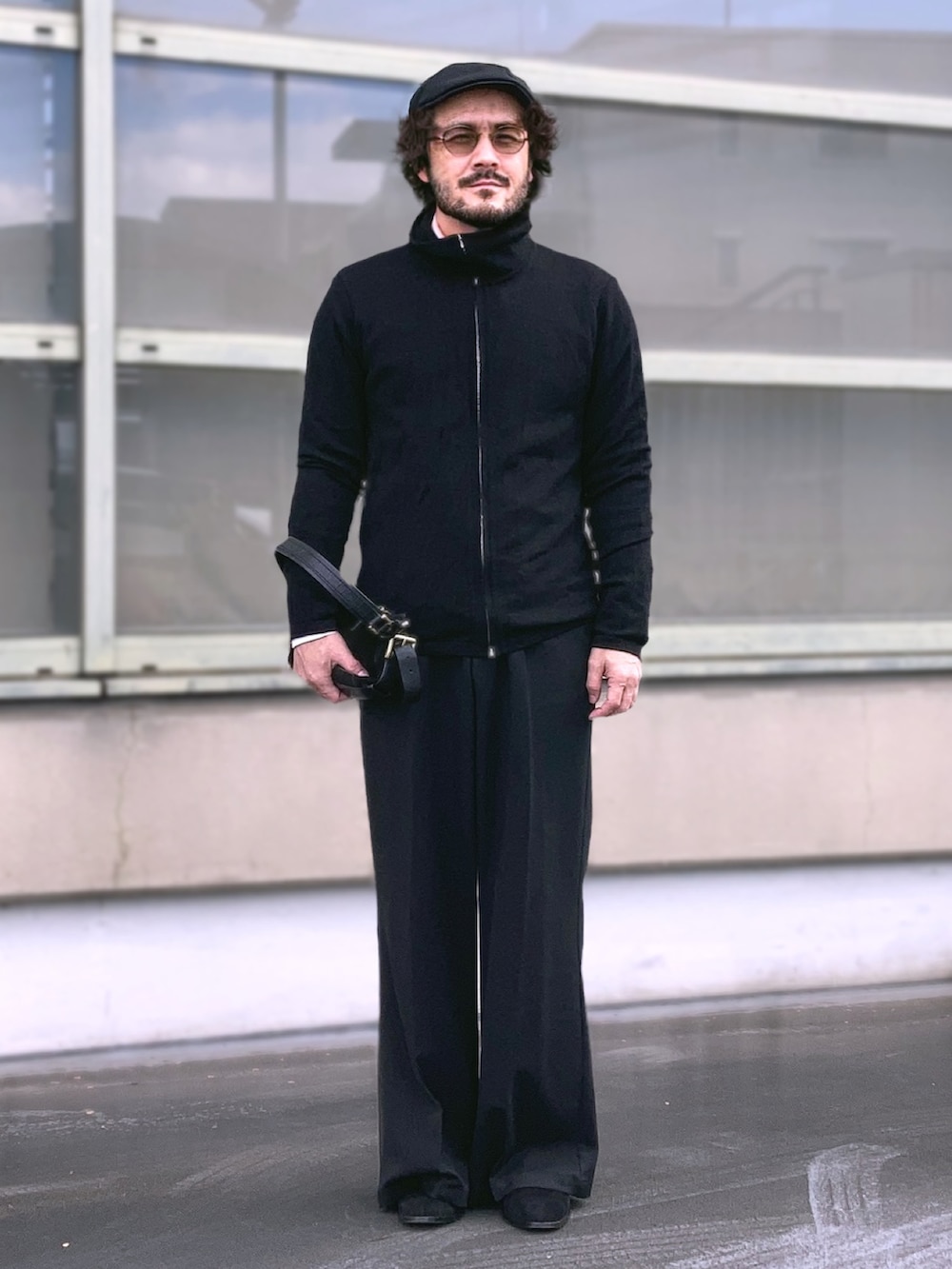 ブラック系のニット/セーター、ホワイト系のシャツ/ブラウス、ブラック系のスラックスを着用したメンズの冬コーディネートの4枚目の写真