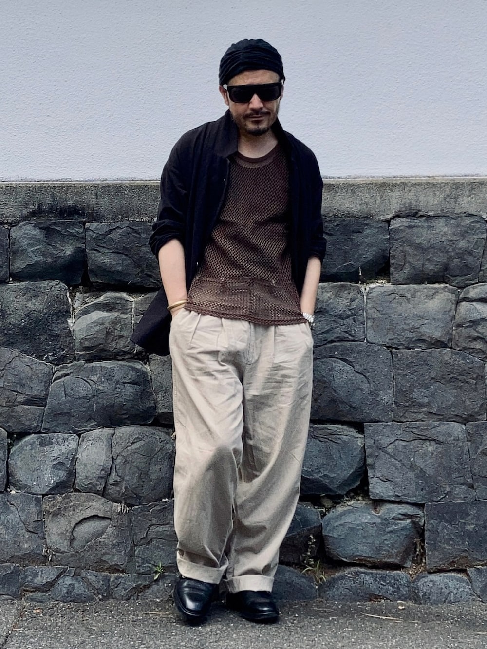 ブラック系のタンクトップ、ブラウン系のタンクトップ、ブラック系のテーラードジャケットを着用したメンズの夏コーディネートの3枚目の写真