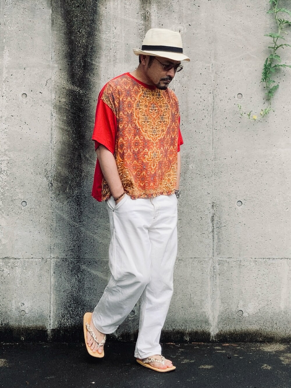 レッド系のTシャツ/カットソー、ホワイト系のデニムパンツ、ベージュ系のサンダルを着用したメンズの夏コーディネートの2枚目の写真
