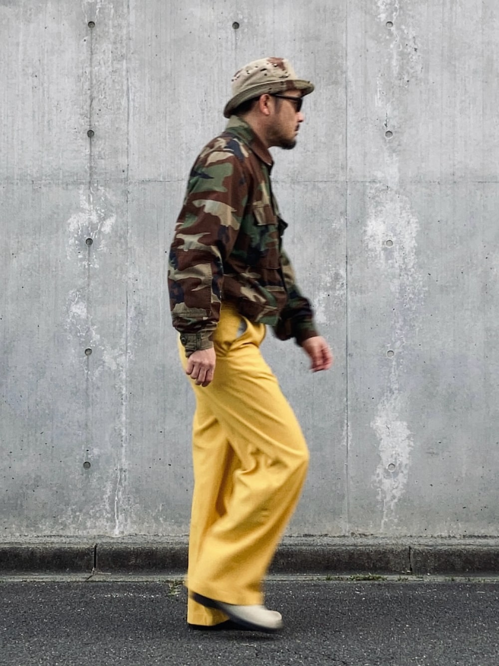 イエロー系のスラックス、その他のミリタリージャケット、ベージュ系のブーツを着用したメンズの冬コーディネートの2枚目の写真