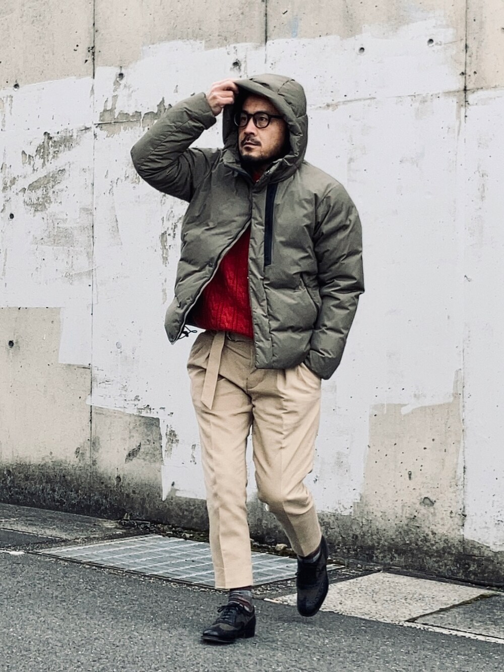 レッド系のニット/セーター、グレー系のジャケット/アウター、ベージュ系のスラックスを着用したメンズの冬コーディネートの4枚目の写真