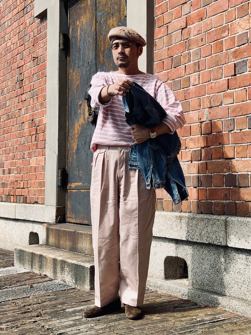 ピンク系のTシャツ/カットソー、ピンク系のスラックス、ブラウン系のスリッポンを着用したメンズの秋コーディネートの3枚目の写真