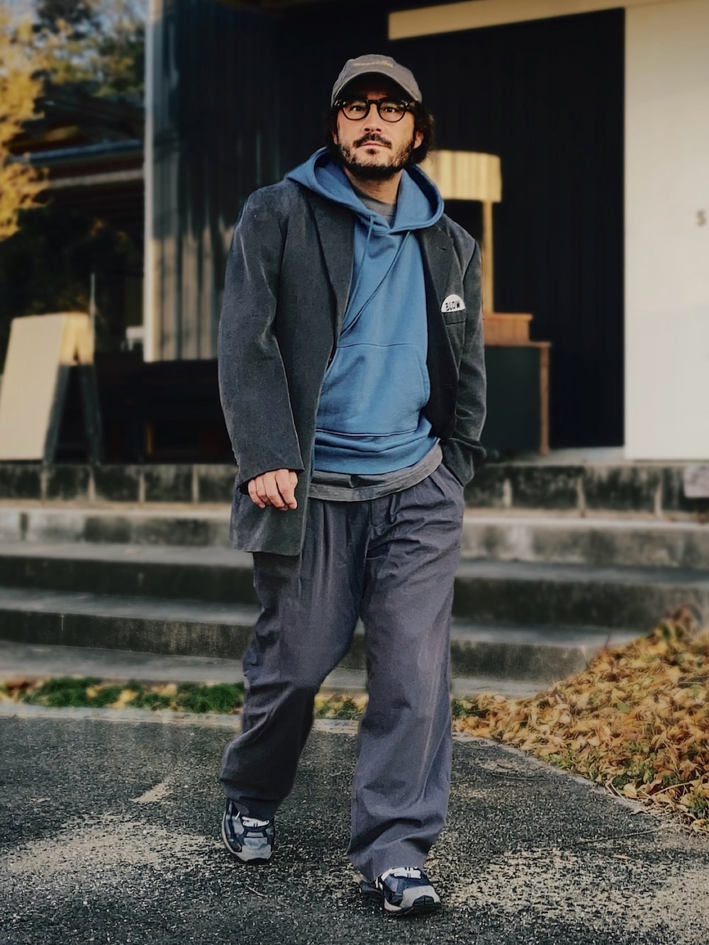 ブルー系のパーカー、グレー系のテーラードジャケット、グレー系のスラックスを着用したメンズの春コーディネートの3枚目の写真