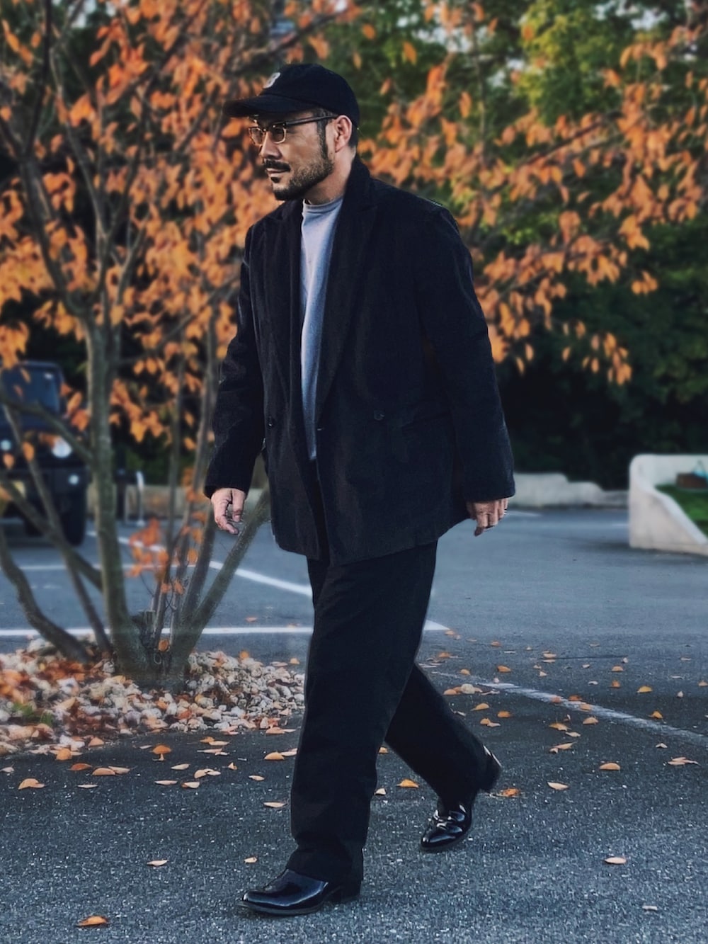 グレー系のテーラードジャケット、グレー系のスウェット、ブラック系のパンツを着用したメンズの秋コーディネートの3枚目の写真