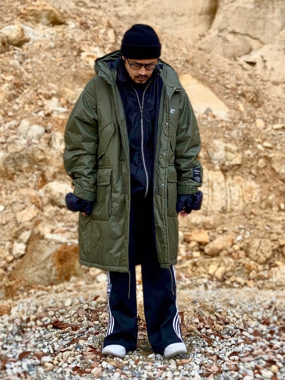 ブルー系のTシャツ/カットソー、ブラック系のベスト、グリーン系のミリタリージャケットを着用したメンズの冬コーディネートの3枚目の写真