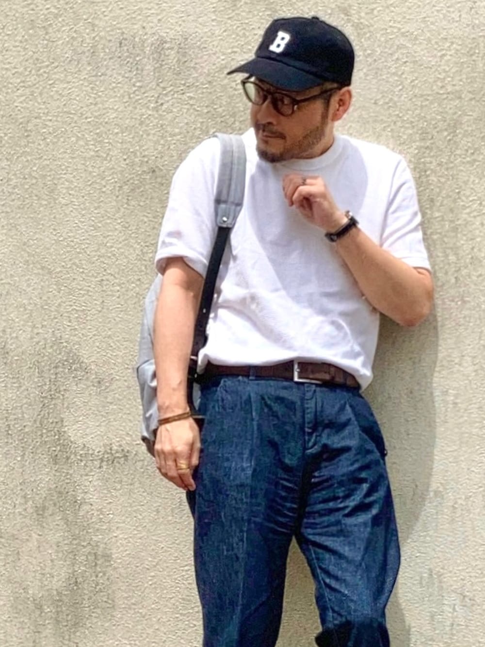 ホワイト系のTシャツ/カットソー、ブルー系のデニムパンツ、ブラウン系のドレスシューズを着用したメンズの春コーディネートの3枚目の写真
