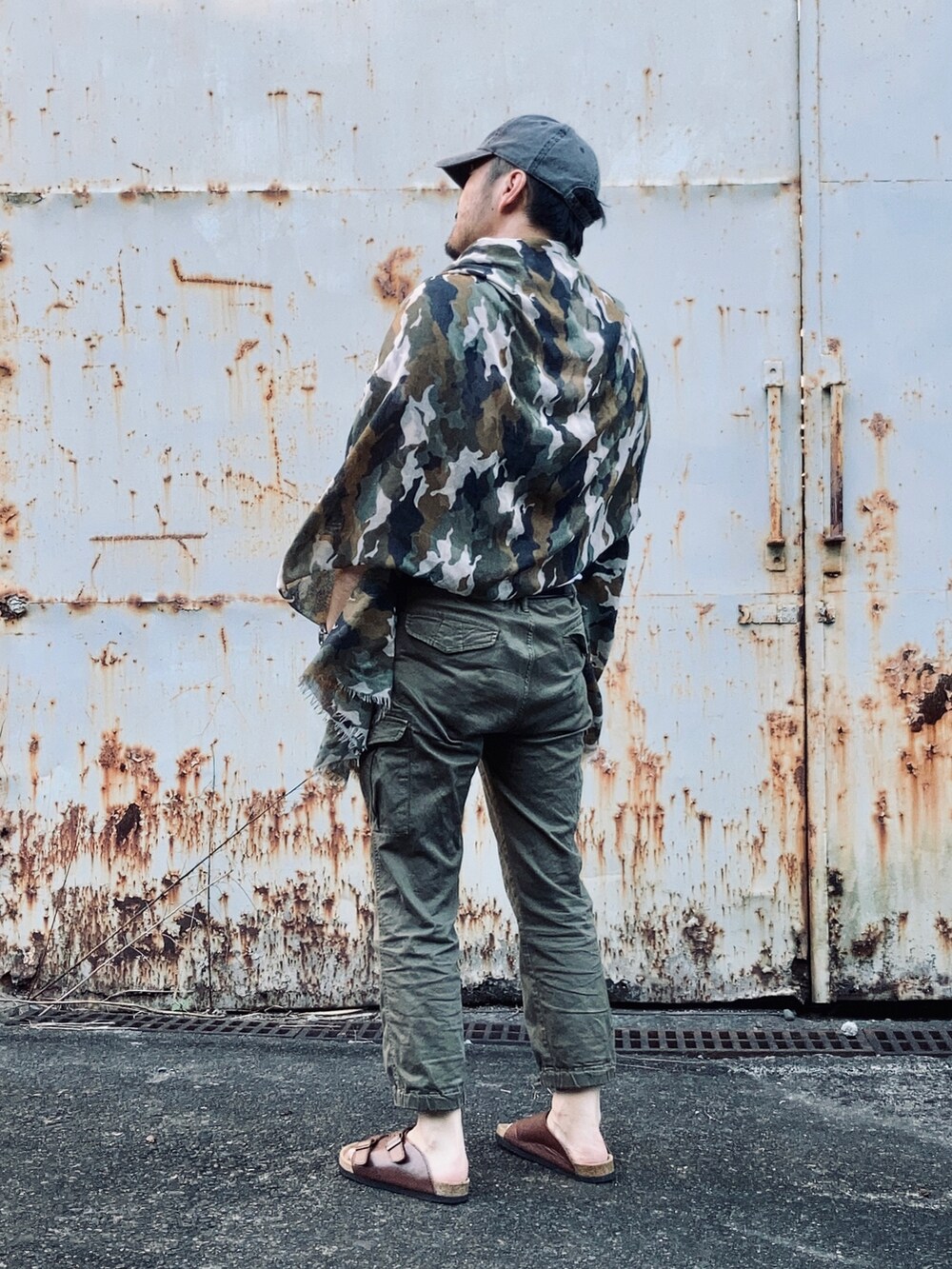 ホワイト系のTシャツ/カットソー、グリーン系のパンツ、ブラウン系のサンダルを着用したメンズの夏コーディネートの4枚目の写真