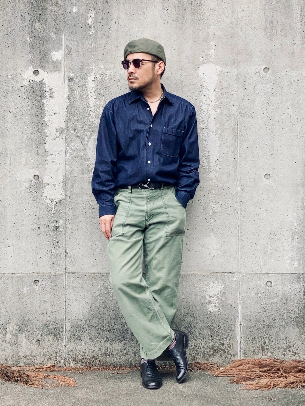 ブルー系のシャツ/ブラウス、グリーン系のパンツ、ブラック系のドレスシューズを着用したメンズの春コーディネートの3枚目の写真