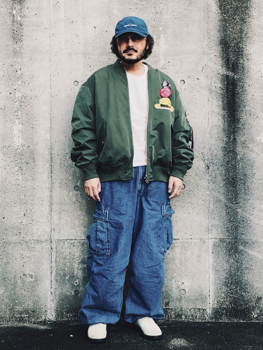 グリーン系のMA-1、ブルー系のカーゴパンツ、ベージュ系のブーツを着用したメンズの冬コーディネートの3枚目の写真