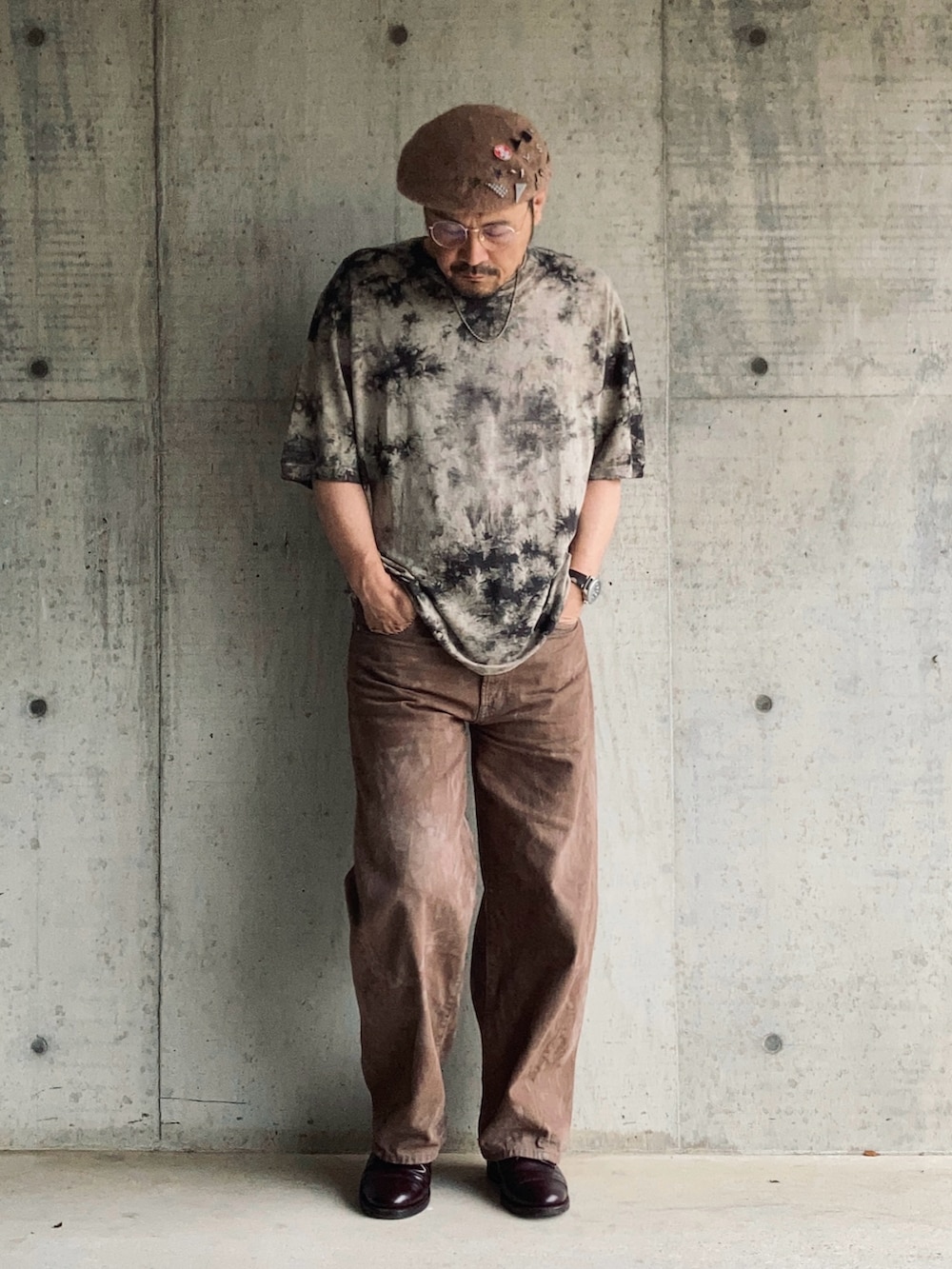 ブラウン系のTシャツ/カットソー、ブラウン系のデニムパンツ、レッド系のドレスシューズを着用したメンズの夏コーディネートの2枚目の写真