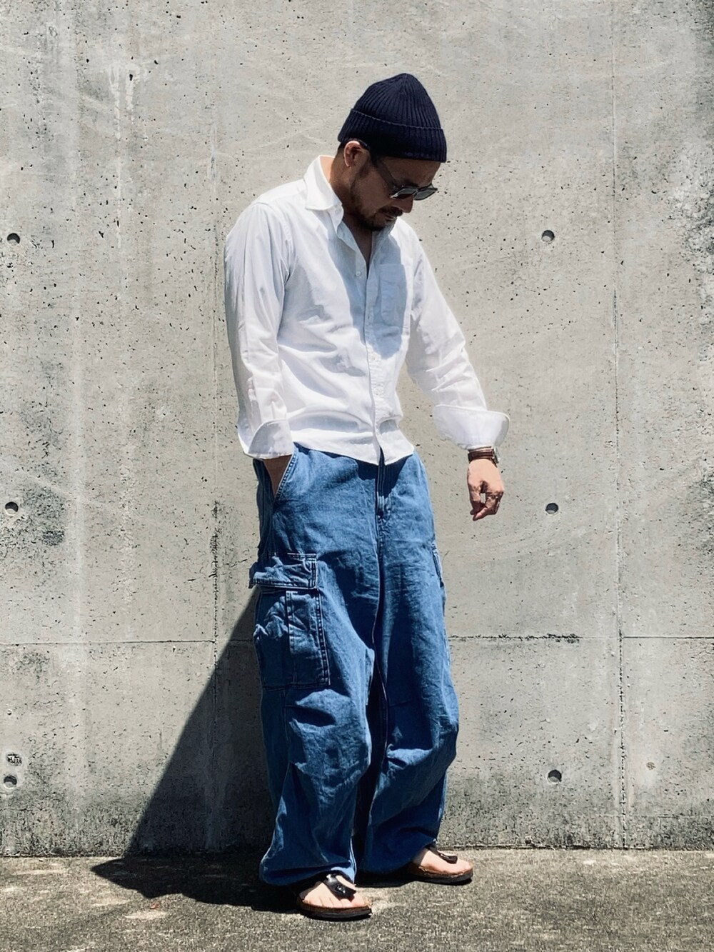 ホワイト系のシャツ/ブラウス、ブルー系のカーゴパンツ、ブラック系のサンダルを着用したメンズの春コーディネートの3枚目の写真