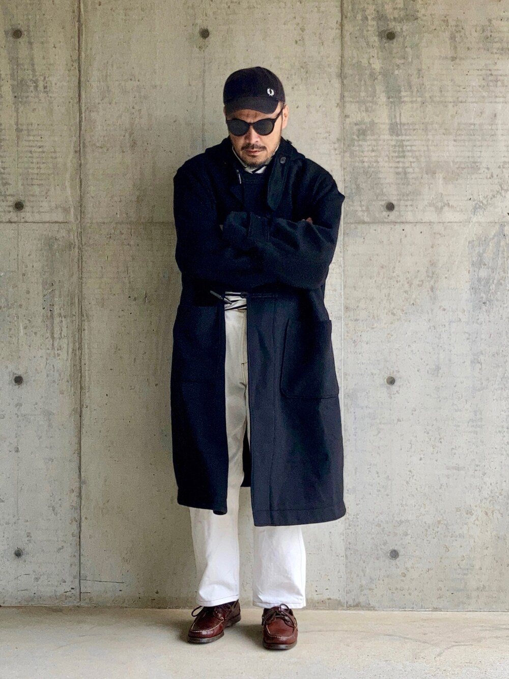 ブラック系のTシャツ/カットソー、ブラック系のダッフルコート、ホワイト系のデニムパンツを着用したメンズの秋コーディネートの3枚目の写真