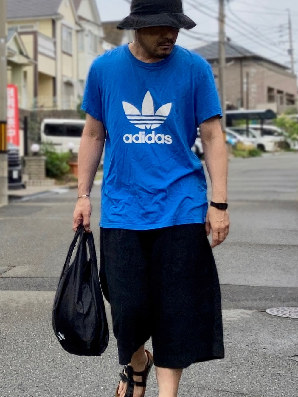 ブルー系のTシャツ/カットソー、ブラック系のその他パンツ、ブラック系のサンダルを着用したメンズの夏コーディネートの3枚目の写真