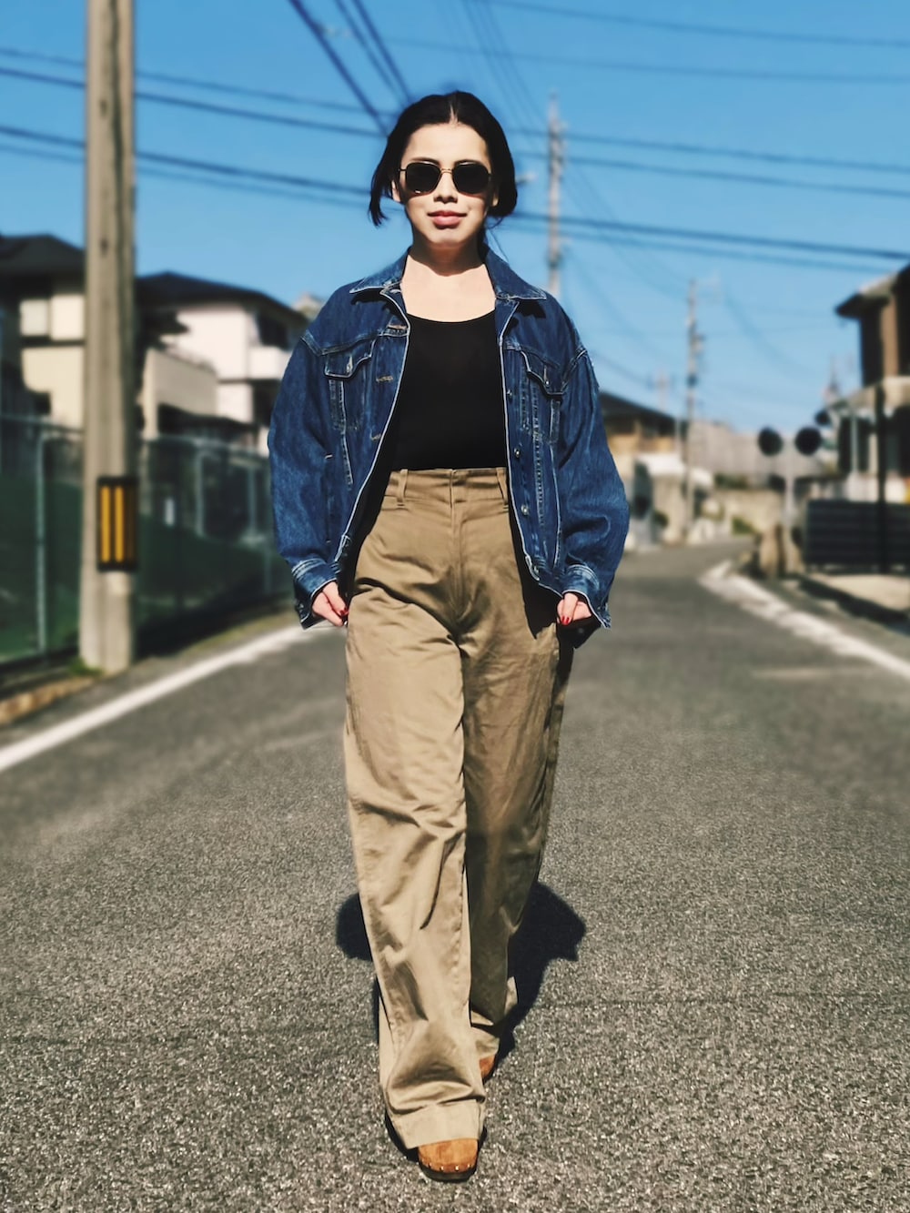 ブルー系のデニムジャケット、ベージュ系のチノパンツを着用したレディースの春コーディネートの2枚目の写真