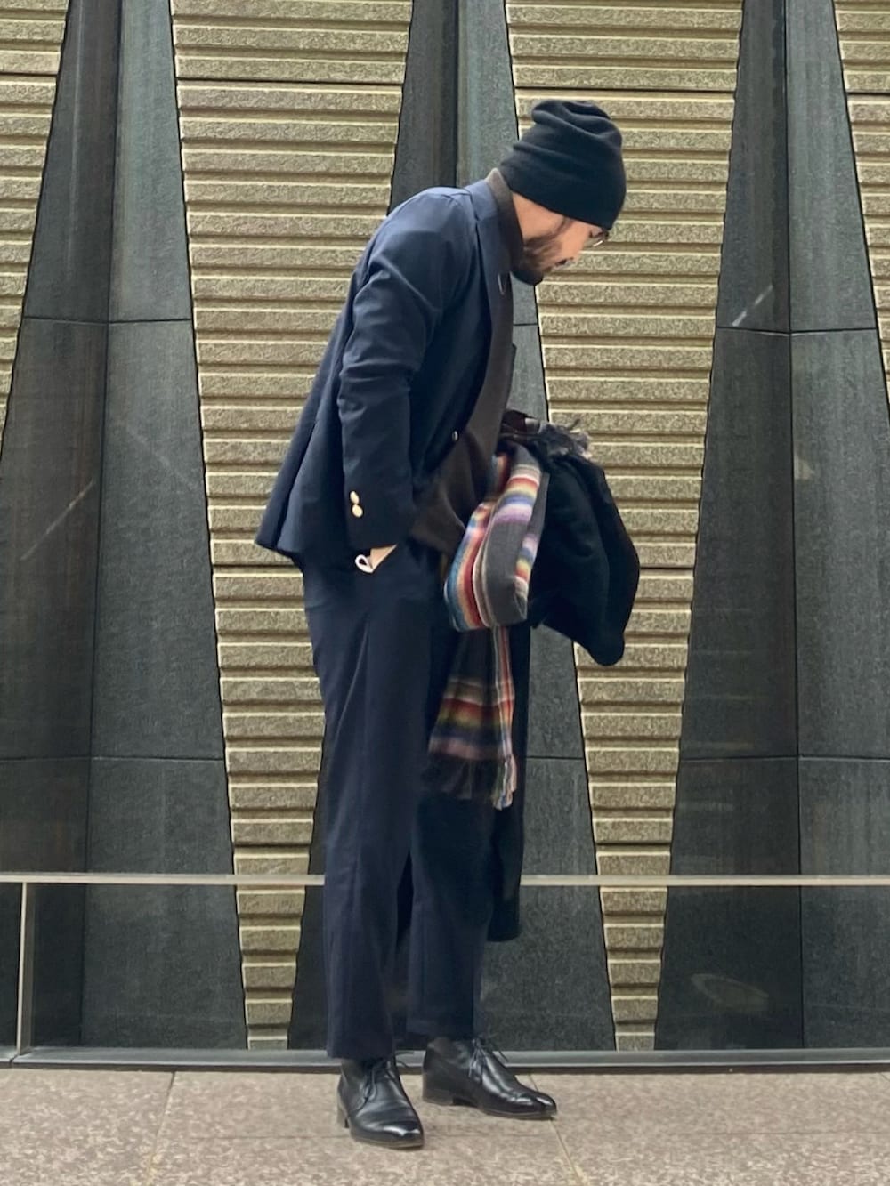 ブラウン系のニット/セーター、ブルー系のテーラードジャケット、ブルー系のスラックスを着用したメンズの冬コーディネートの3枚目の写真