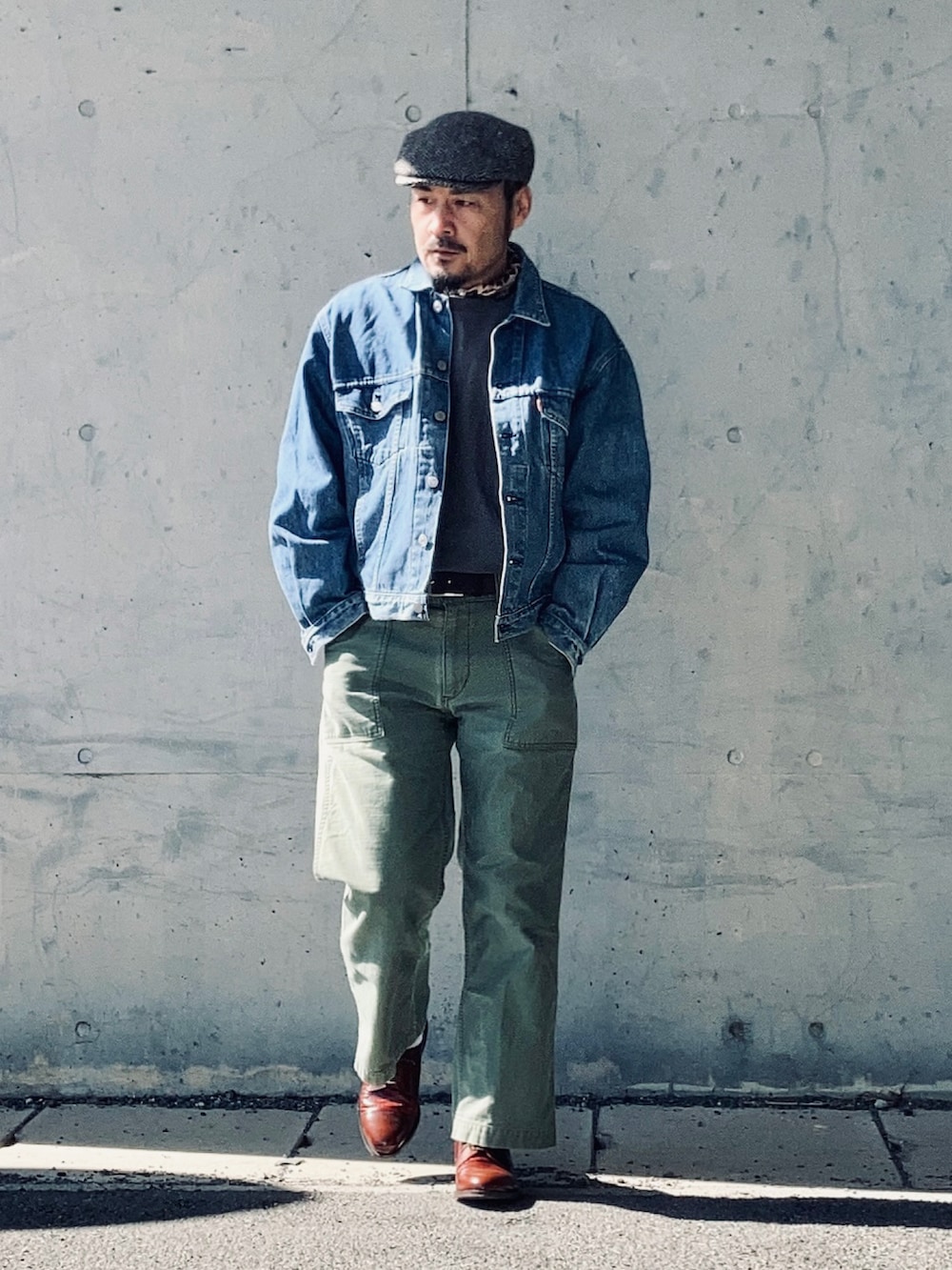 ブルー系のデニムジャケット、グリーン系のパンツ、ブラウン系のドレスシューズを着用したメンズの冬コーディネートの4枚目の写真