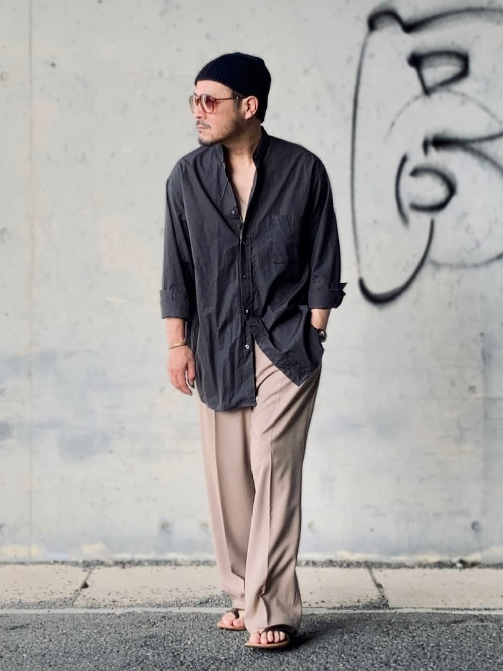 グレー系のシャツ/ブラウス、ベージュ系のスラックス、ブラウン系のサンダルを着用したメンズの夏コーディネートの2枚目の写真