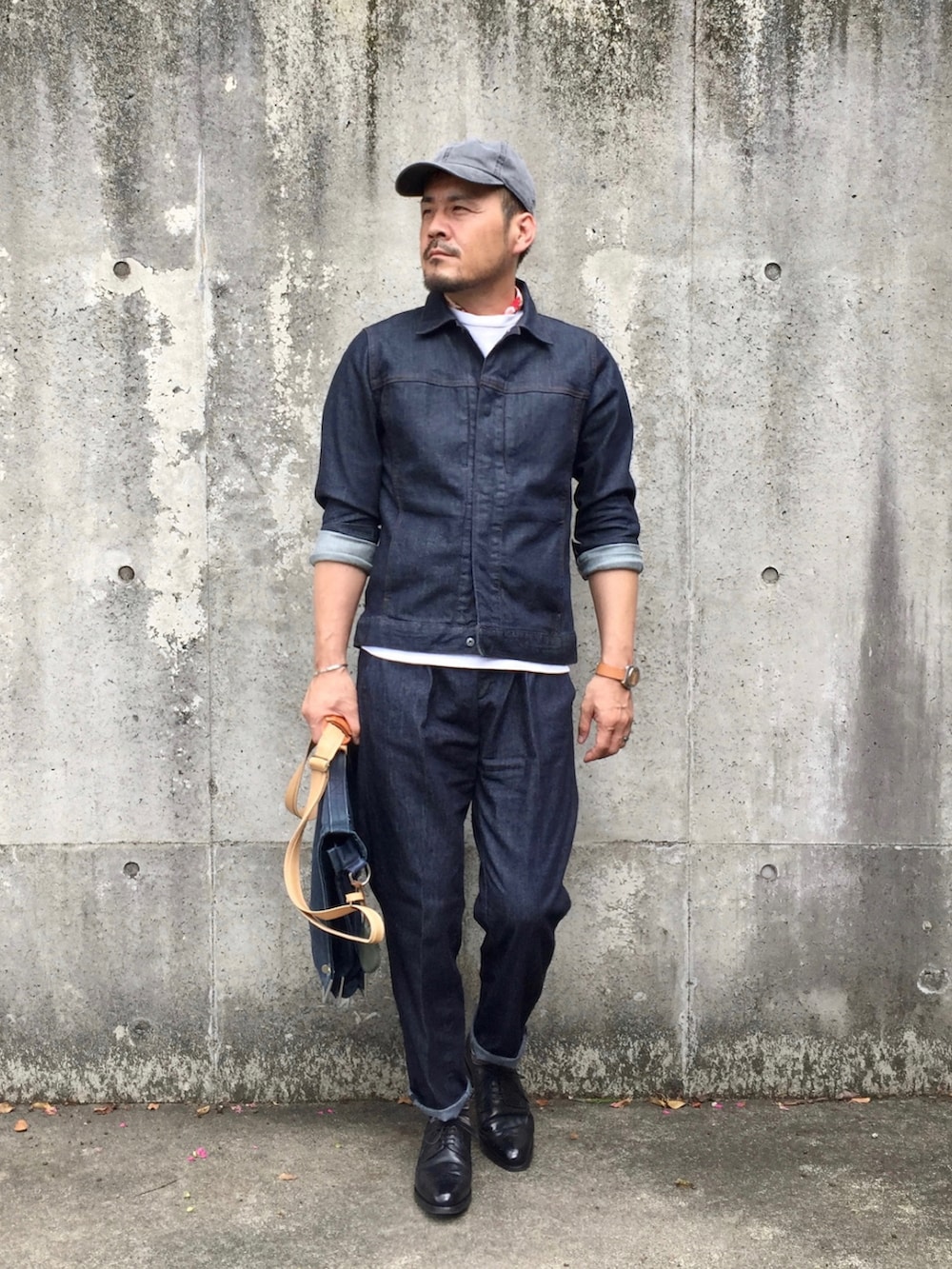 グレー系のニット/セーター、ブルー系のデニムジャケット、ブルー系のデニムパンツを着用したメンズの春コーディネートの3枚目の写真