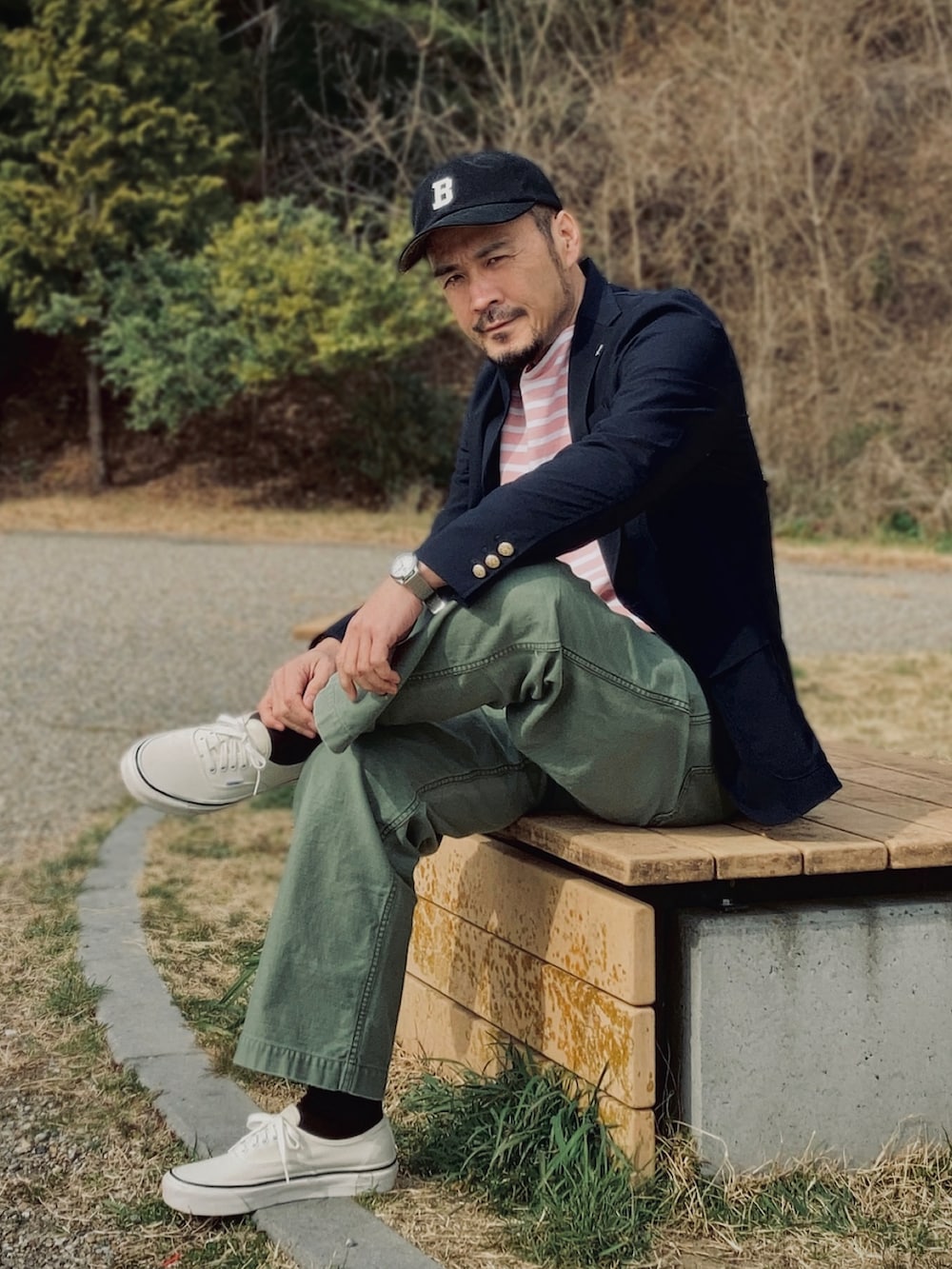 ピンク系のTシャツ/カットソー、ブルー系のテーラードジャケット、グリーン系のパンツを着用したメンズの春コーディネートの3枚目の写真