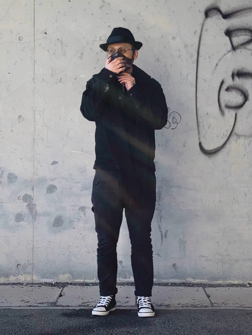 ブラック系のデニムジャケット、ブラック系のデニムパンツ、ブラック系のスニーカーを着用したメンズの冬コーディネートの2枚目の写真