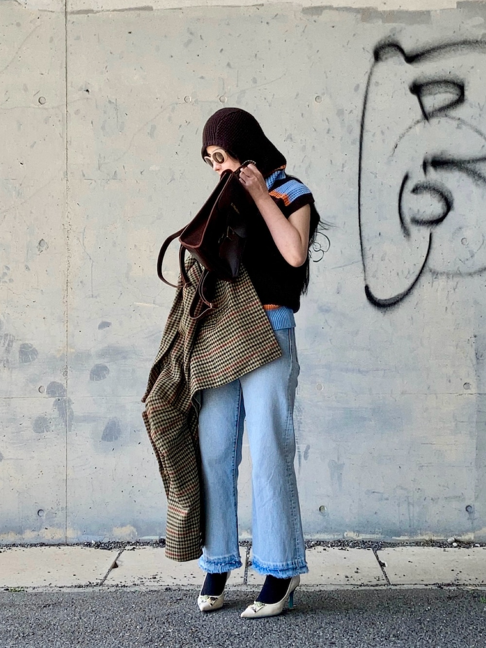 ブラウン系のベスト、ベージュ系のテーラードジャケット、ブラウン系のバックパック/リュックを着用したレディースの春コーディネートの3枚目の写真