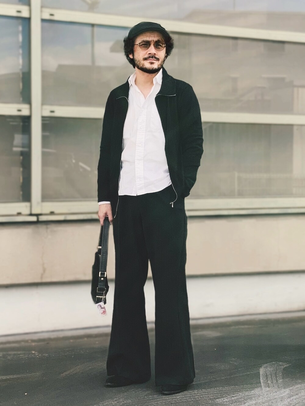 ブラック系のニット/セーター、ホワイト系のシャツ/ブラウス、ブラック系のスラックスを着用したメンズの冬コーディネートの2枚目の写真