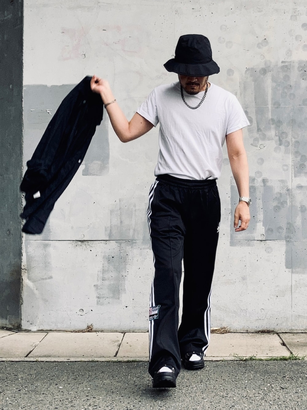 ホワイト系のTシャツ/カットソー、ブラック系のスウェットパンツ、ブラック系のサンダルを着用したメンズの夏コーディネートの4枚目の写真