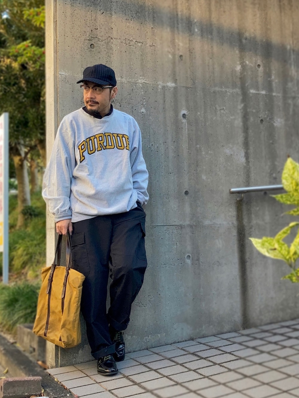 グレー系のスウェット、ブラック系のカーゴパンツ、ブラック系のドレスシューズを着用したメンズの秋コーディネートの2枚目の写真