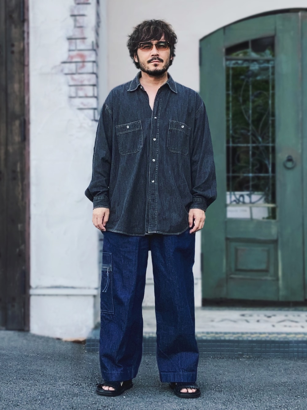 ブラック系のシャツ/ブラウス、ブルー系のデニムパンツ、ブラック系のサンダルを着用したメンズの秋コーディネートの2枚目の写真