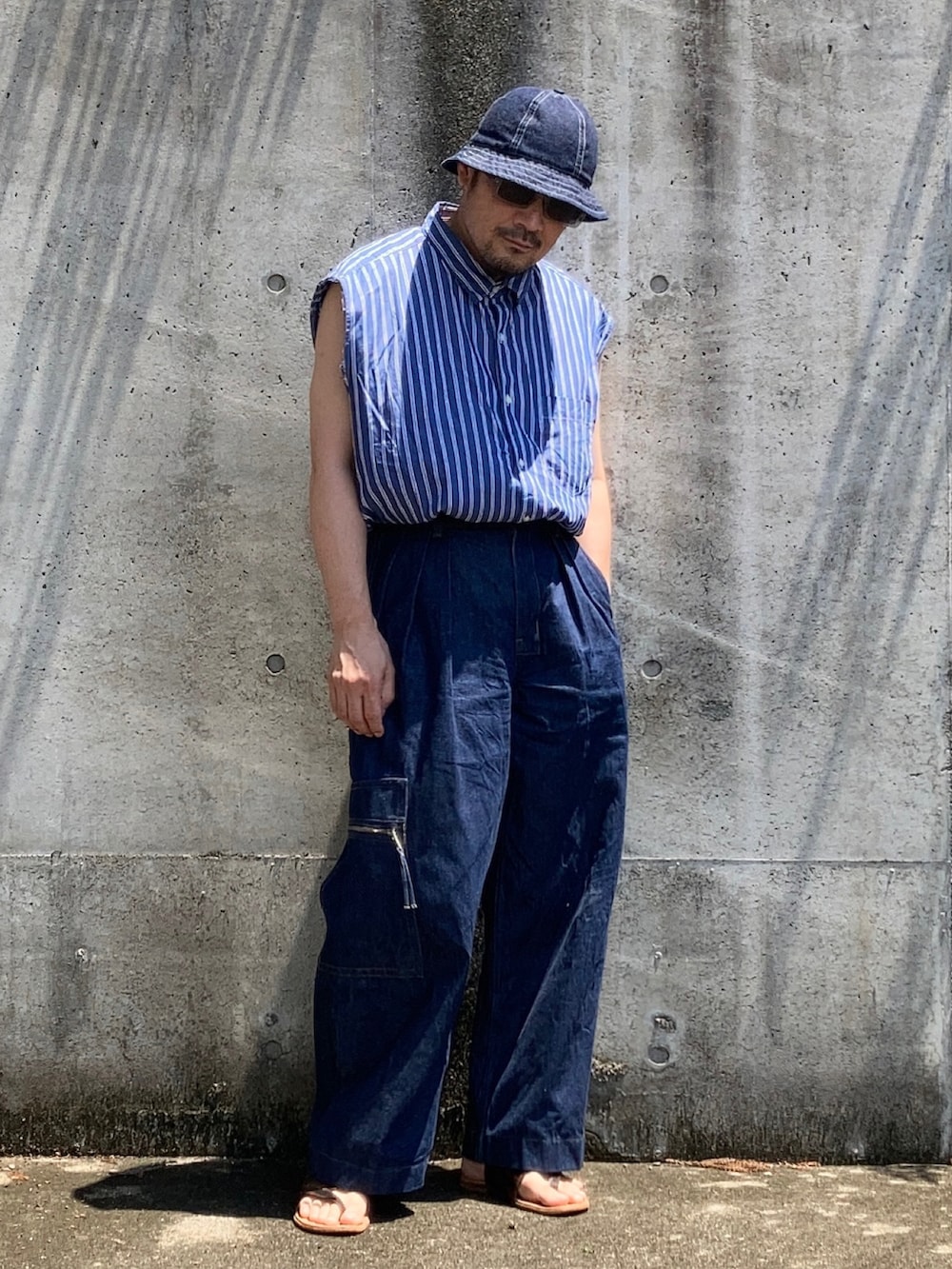 ブルー系のデニムパンツ、ブルー系のシャツ/ブラウス、ブラウン系のタンクトップを着用したメンズの夏コーディネートの3枚目の写真