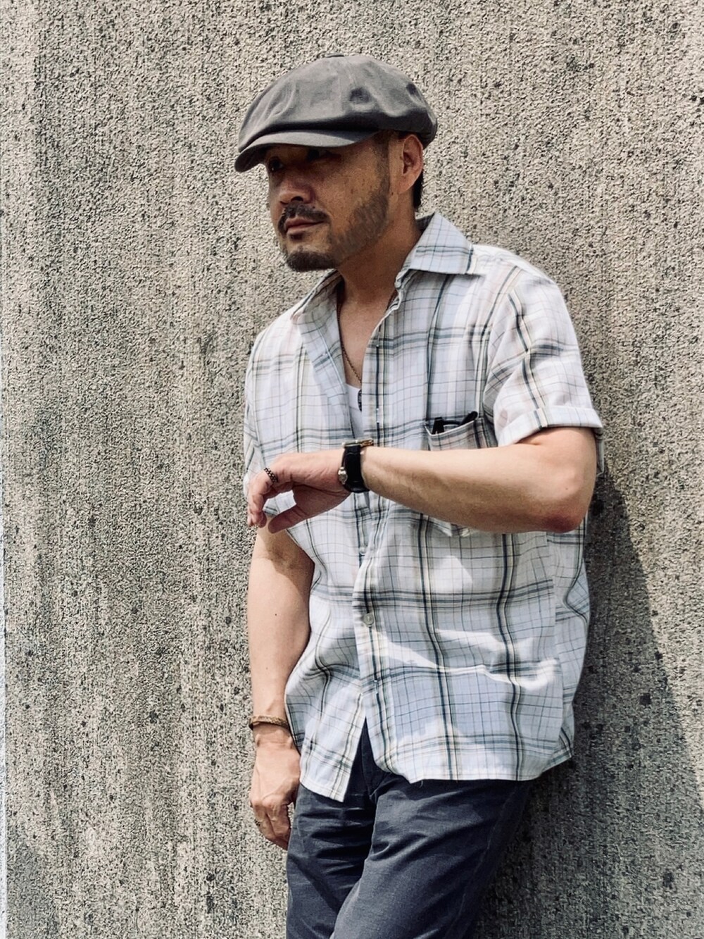 ホワイト系のタンクトップ、グリーン系のシャツ/ブラウス、グレー系のスラックスを着用したメンズの夏コーディネートの3枚目の写真