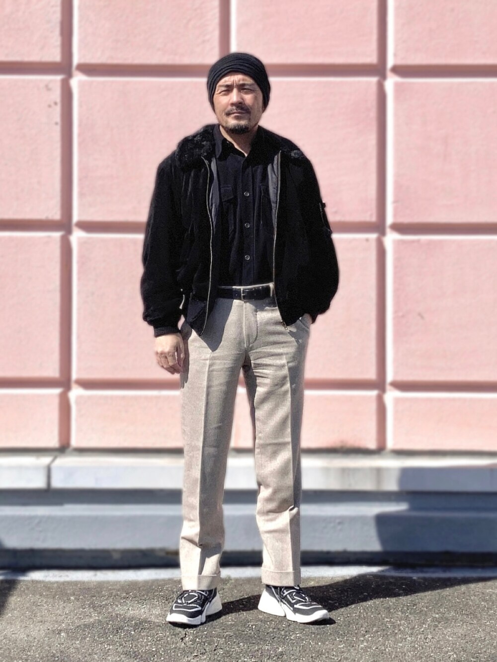 ブラック系のシャツ/ブラウス、ブラック系のブルゾン、ベージュ系のスラックスを着用したメンズの冬コーディネートの4枚目の写真