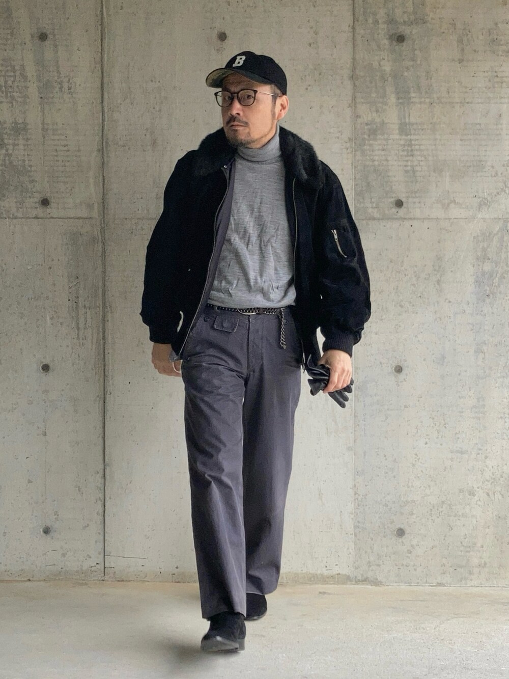 グレー系のニット/セーター、ブラック系のブルゾン、グレー系のスラックスを着用したメンズの冬コーディネートの3枚目の写真