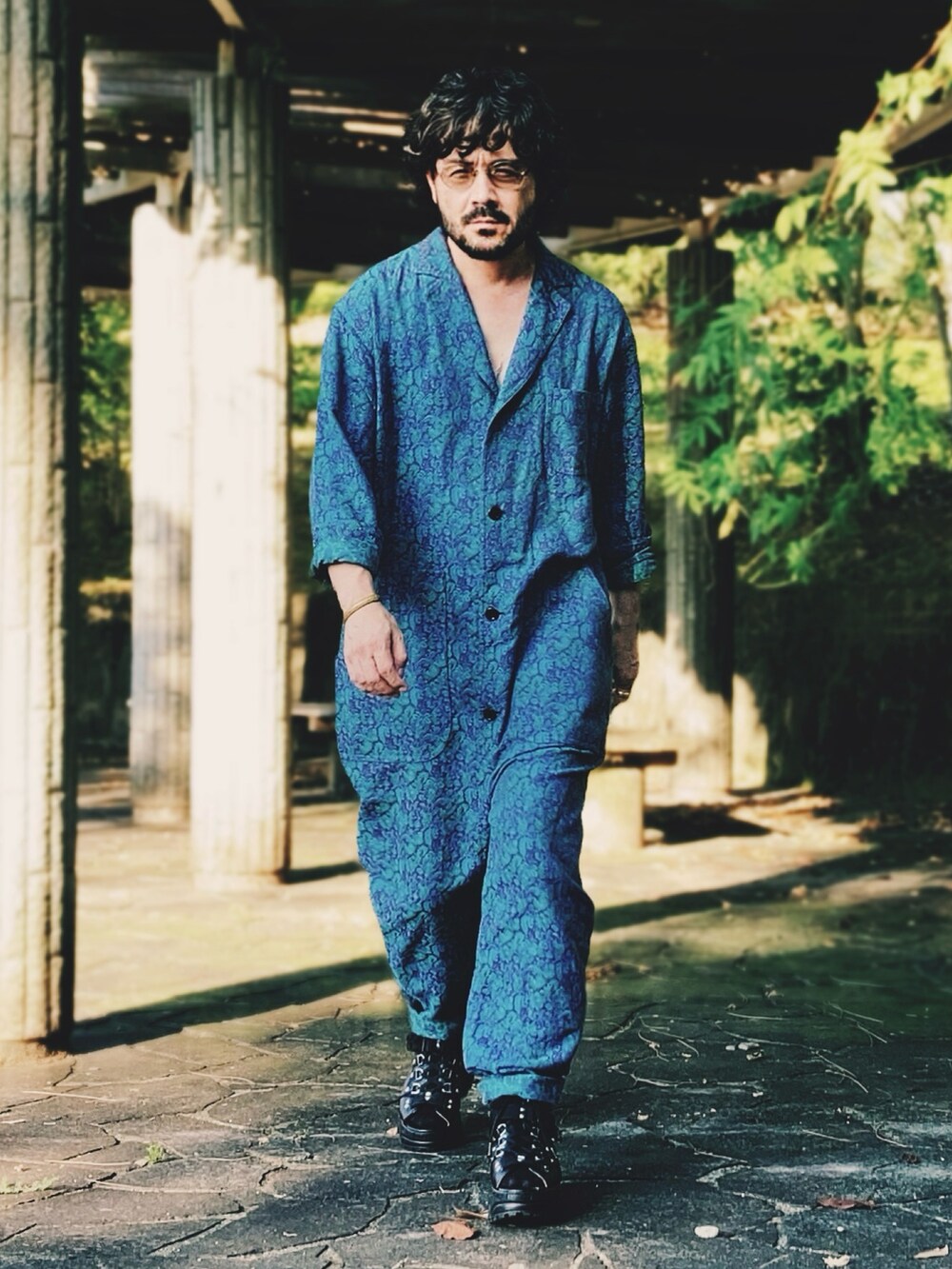 ブルー系のつなぎ/オールインワン、ブラック系のサンダル、ブラウン系のサングラスを着用したメンズの秋コーディネートの2枚目の写真