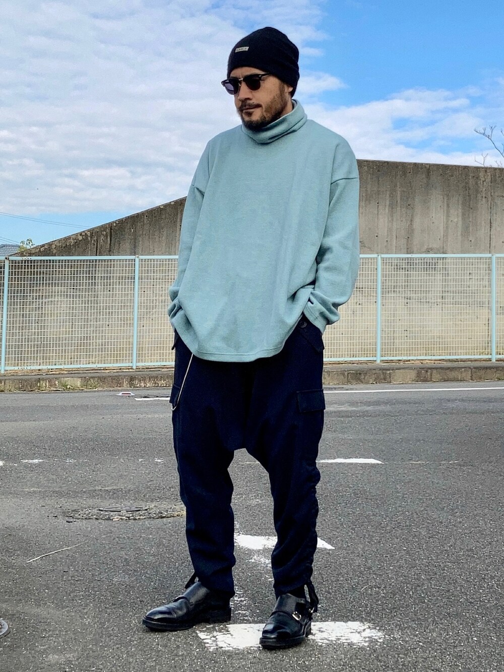 ブルー系のニット/セーター、ブラック系のその他パンツ、ブラック系のドレスシューズを着用したメンズの秋コーディネートの2枚目の写真