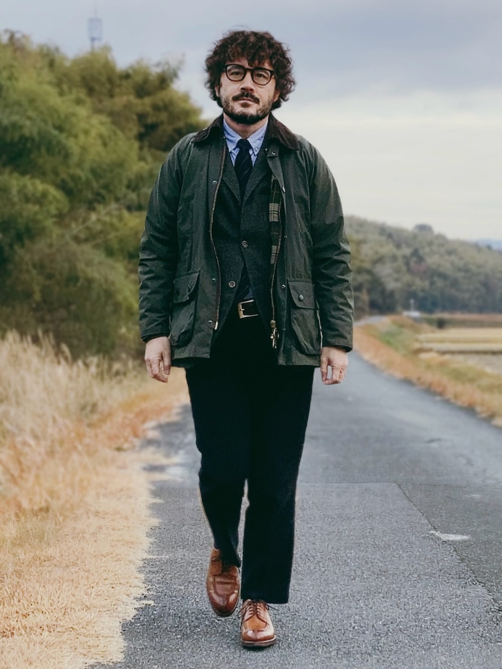 グリーン系のその他アウター、グレー系のテーラードジャケット、ブラック系のスラックスを着用したメンズの冬コーディネートの2枚目の写真