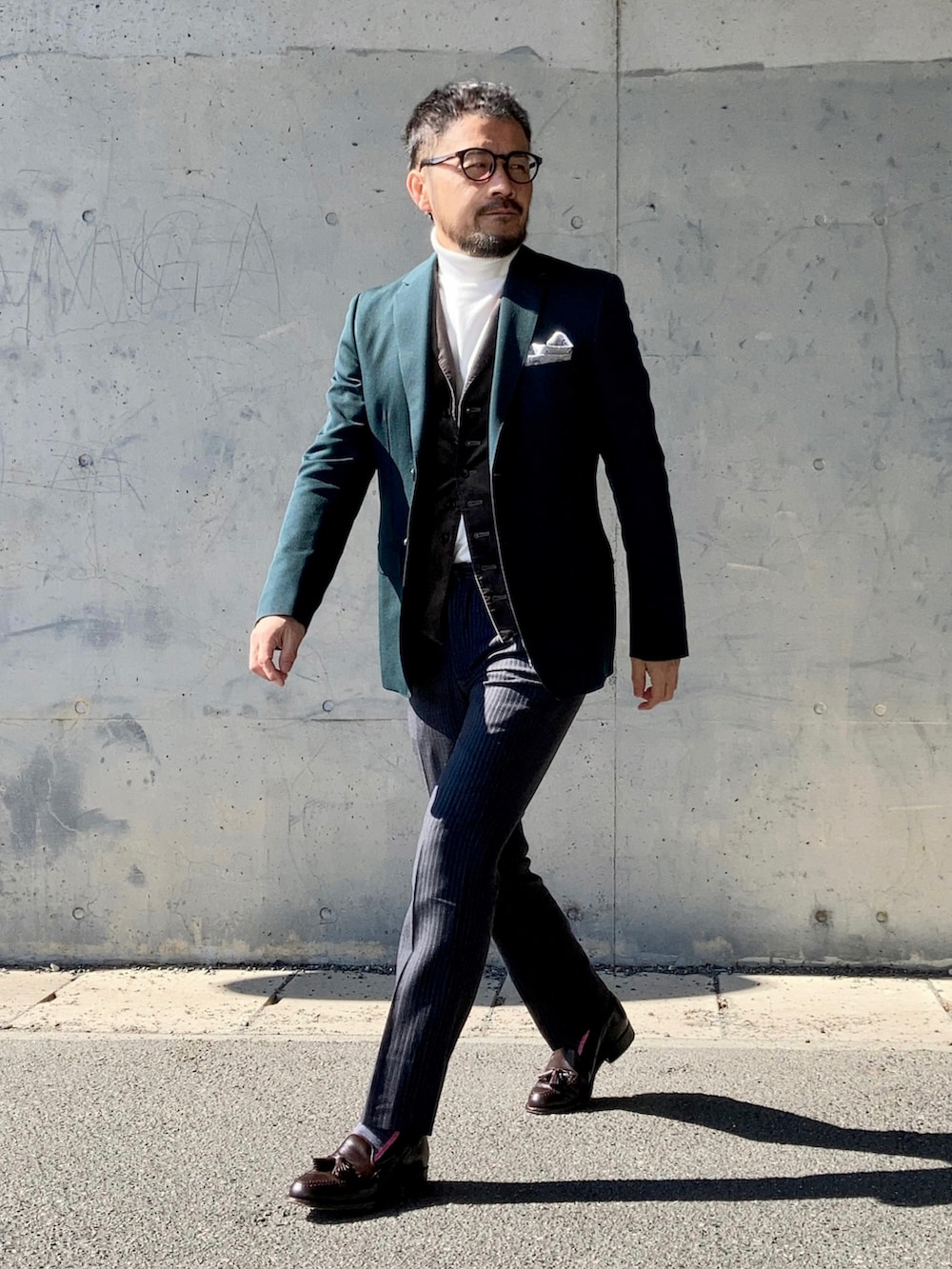 ホワイト系のニット/セーター、グリーン系のテーラードジャケット、グレー系のスラックスを着用したメンズの冬コーディネートの2枚目の写真