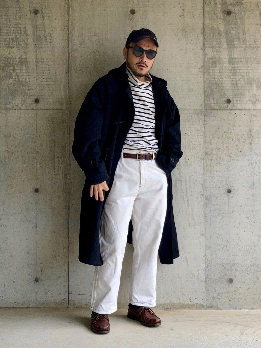 ブラック系のTシャツ/カットソー、ブラック系のダッフルコート、ホワイト系のデニムパンツを着用したメンズの秋コーディネートの2枚目の写真