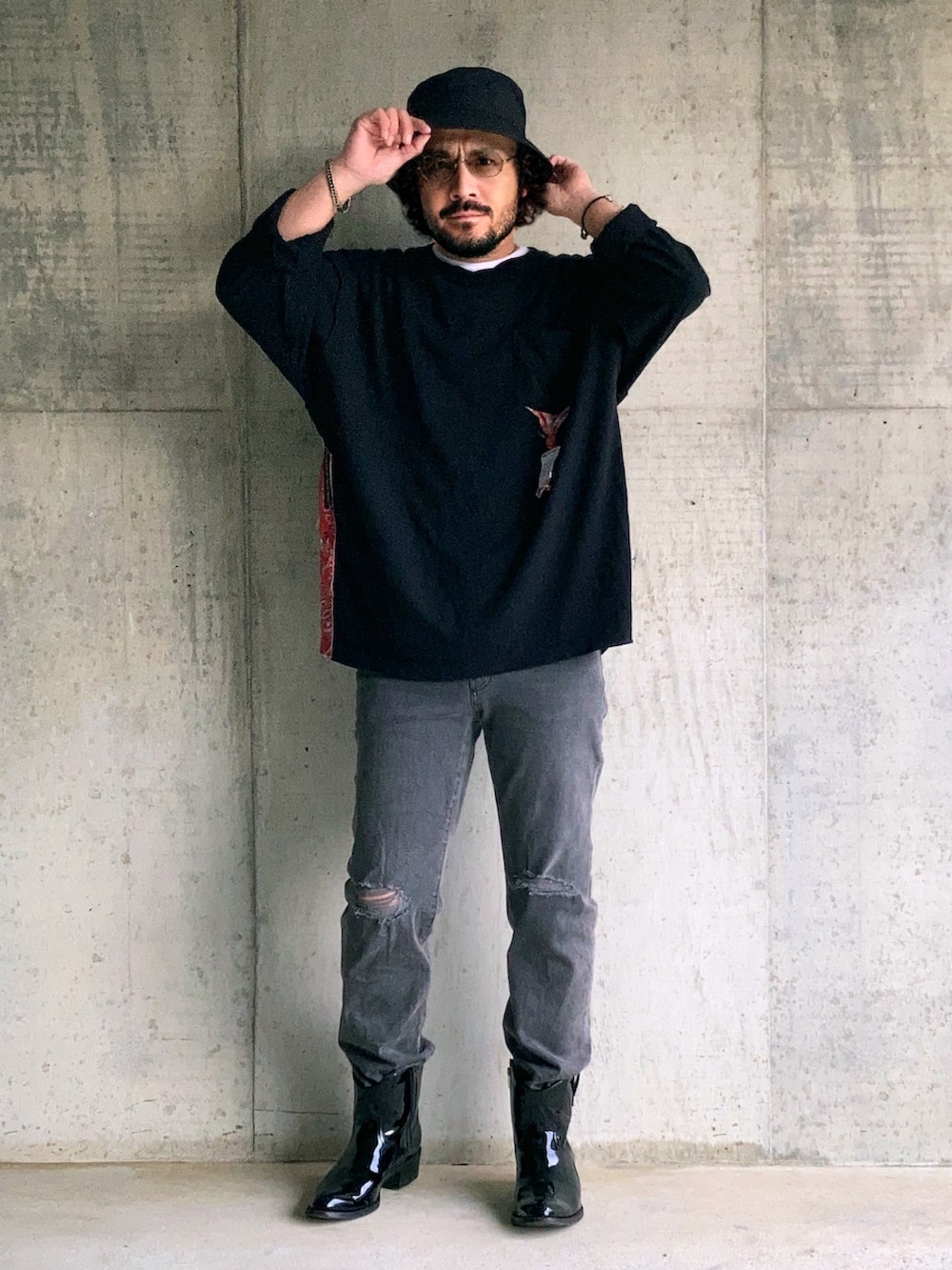 ブラック系のTシャツ/カットソー、グレー系のデニムパンツ、ブラック系のブーツを着用したメンズの秋コーディネートの2枚目の写真