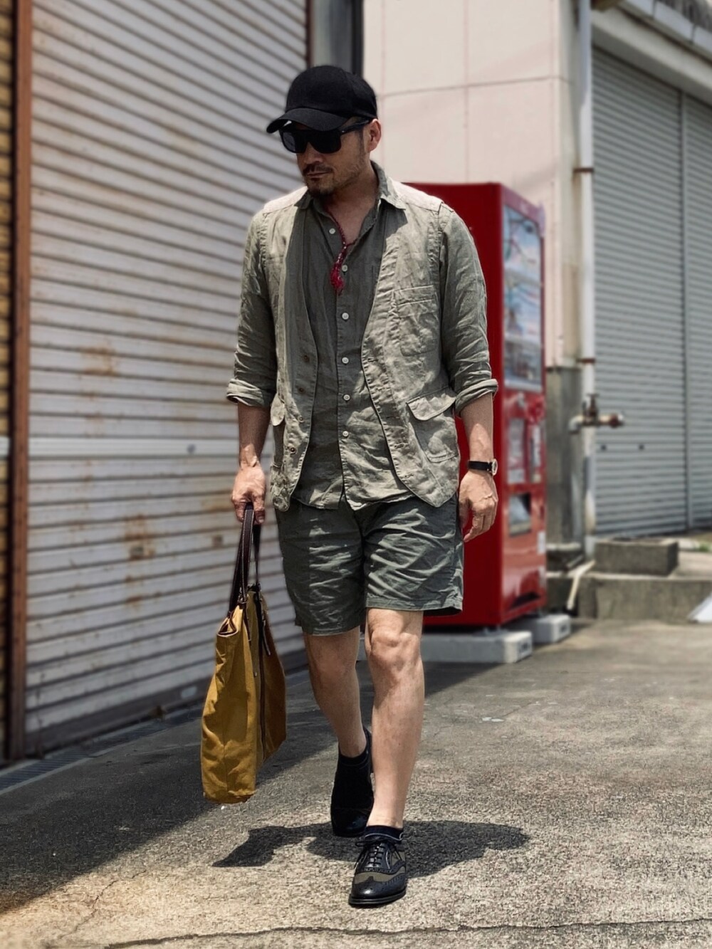 グリーン系のシャツ/ブラウス、グリーン系のベスト、グリーン系のチノパンツを着用したメンズの夏コーディネートの3枚目の写真