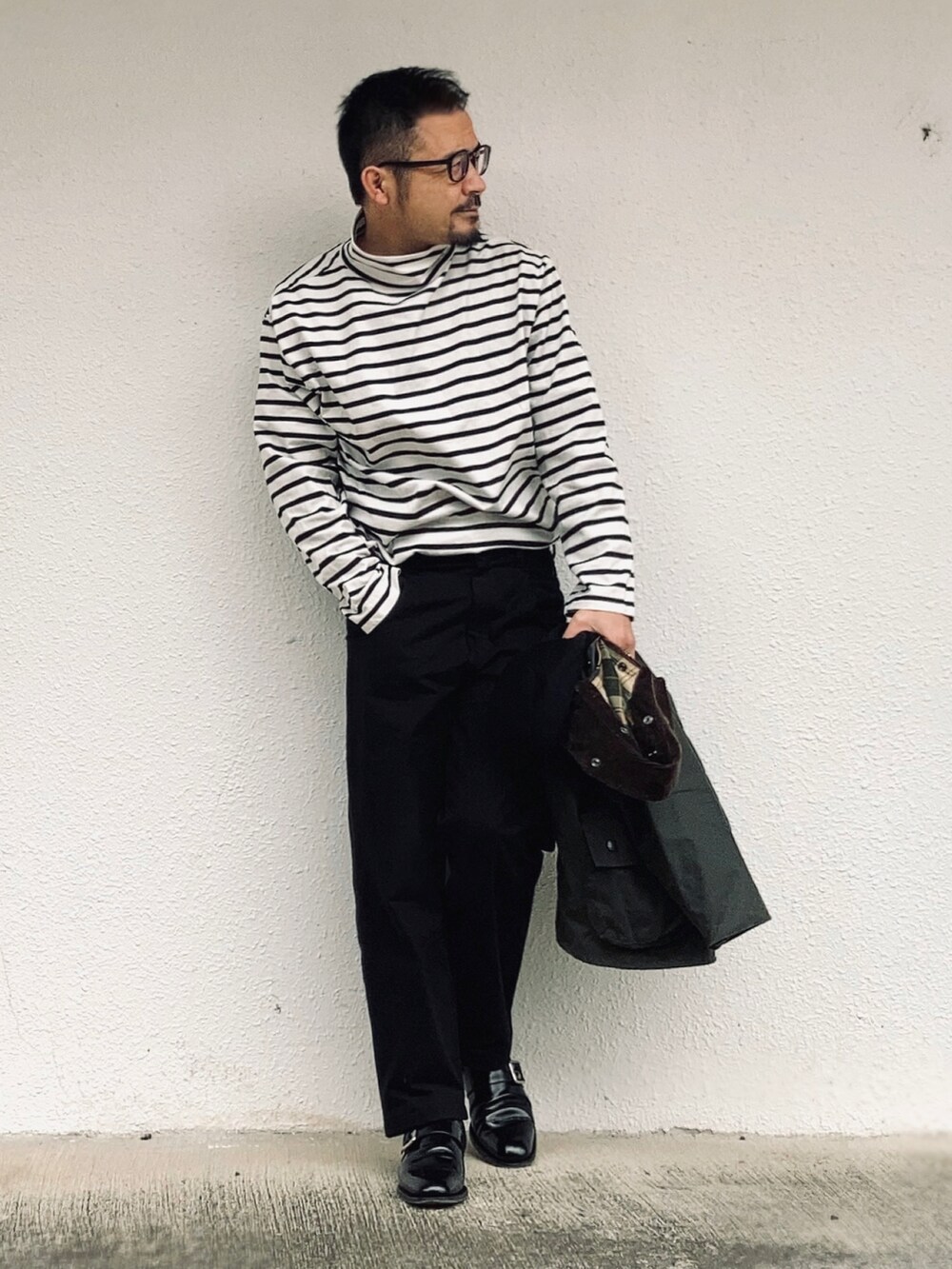ブラック系のTシャツ/カットソー、グリーン系のその他アウター、ブラック系のパンツを着用したメンズの春コーディネートの3枚目の写真