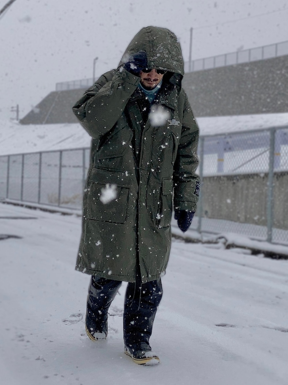 ブルー系のニット/セーター、グリーン系のミリタリージャケット、ブラック系のその他パンツを着用したメンズの冬コーディネートの3枚目の写真