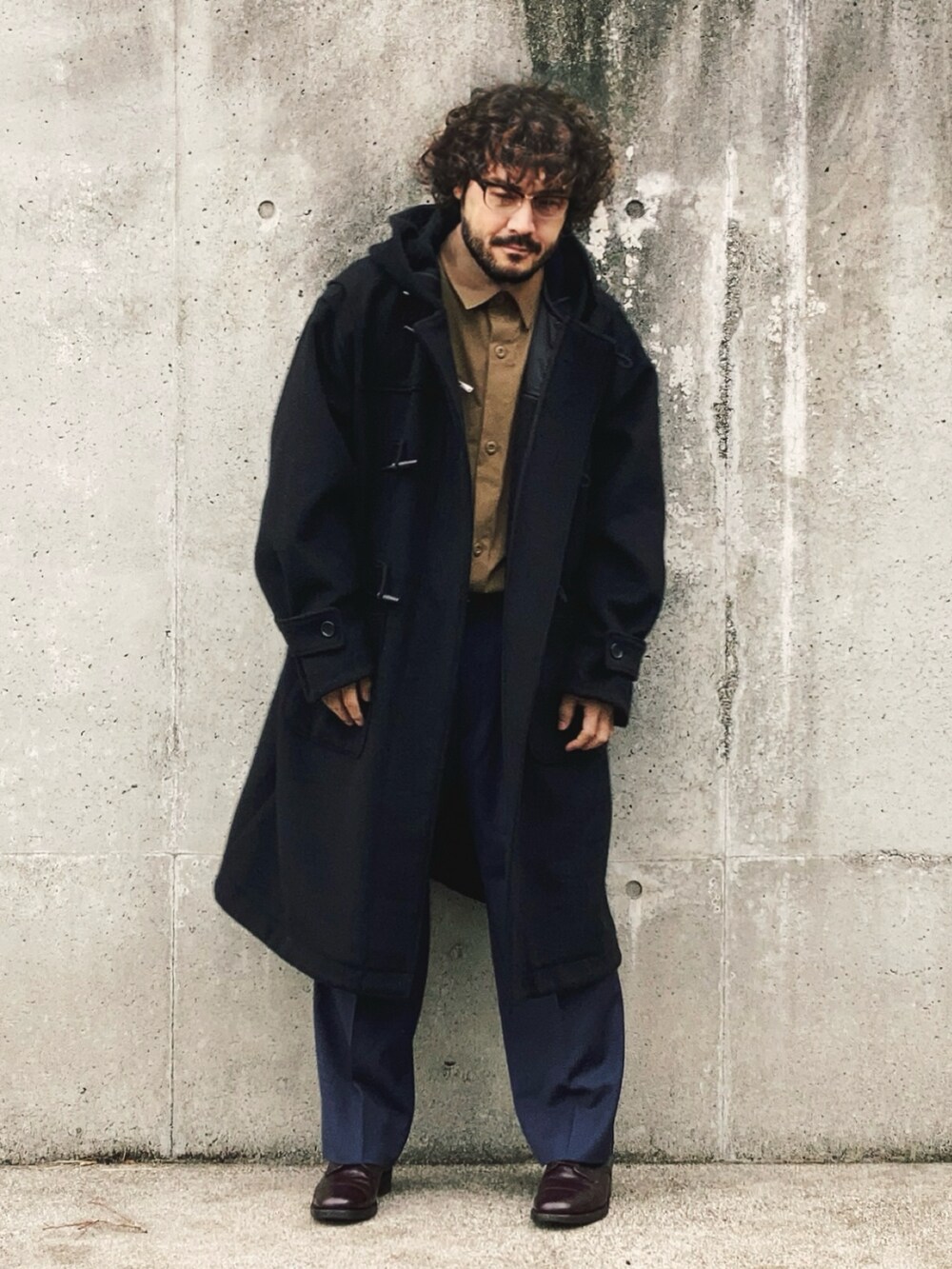 ブラック系のダッフルコート、ベージュ系のセットアップ、ブルー系のスラックスを着用したメンズの秋コーディネートの3枚目の写真