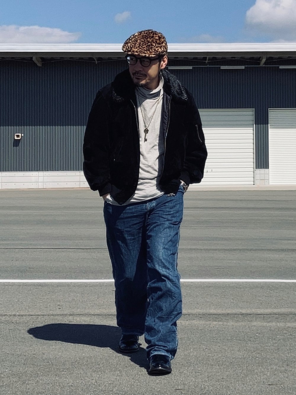 グレー系のTシャツ/カットソー、ブラック系のブルゾン、ブルー系のデニムパンツを着用したメンズの春コーディネートの2枚目の写真