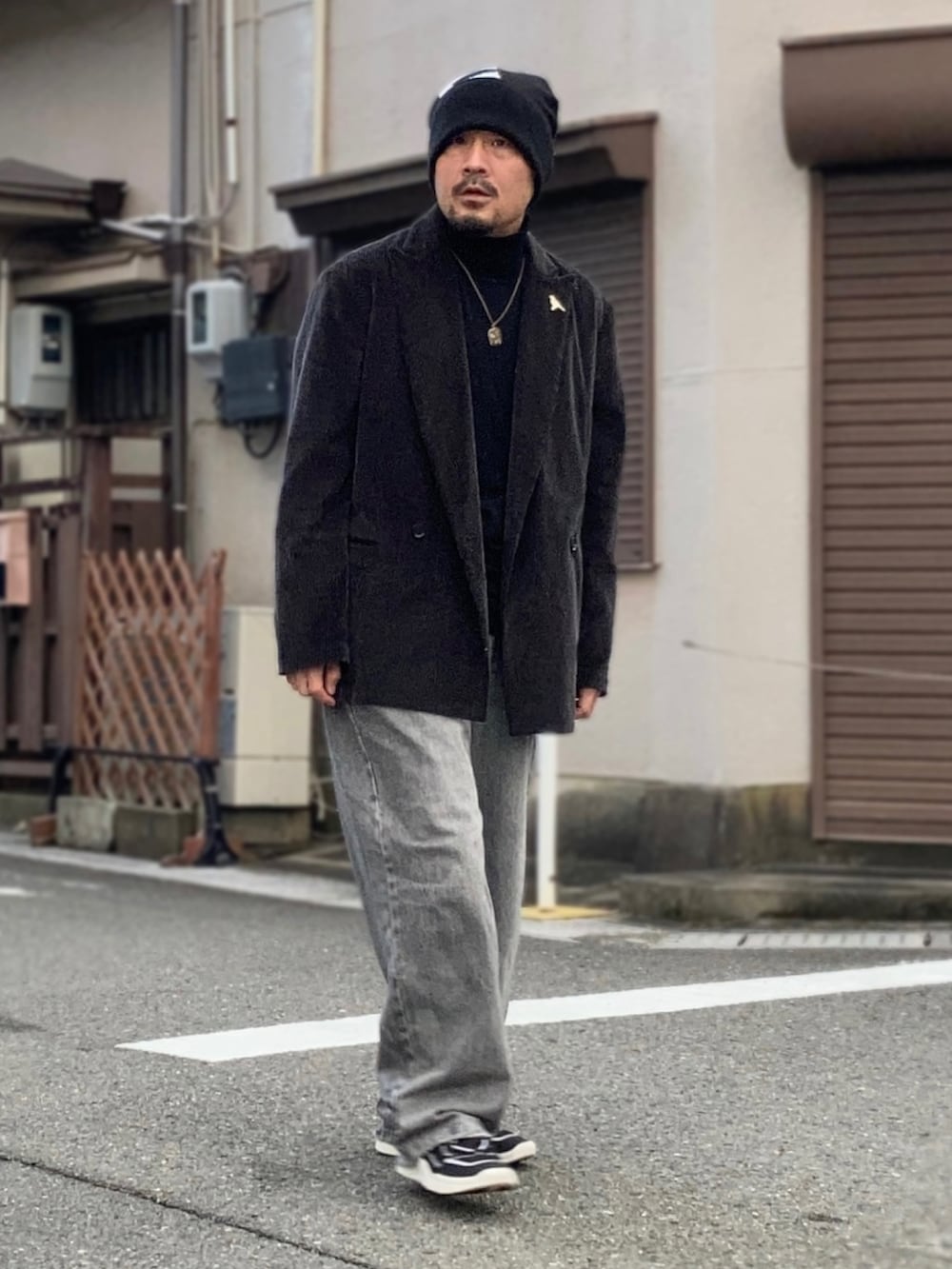 ブラック系のニット/セーター、グレー系のテーラードジャケット、グレー系のデニムパンツを着用したメンズの冬コーディネートの4枚目の写真