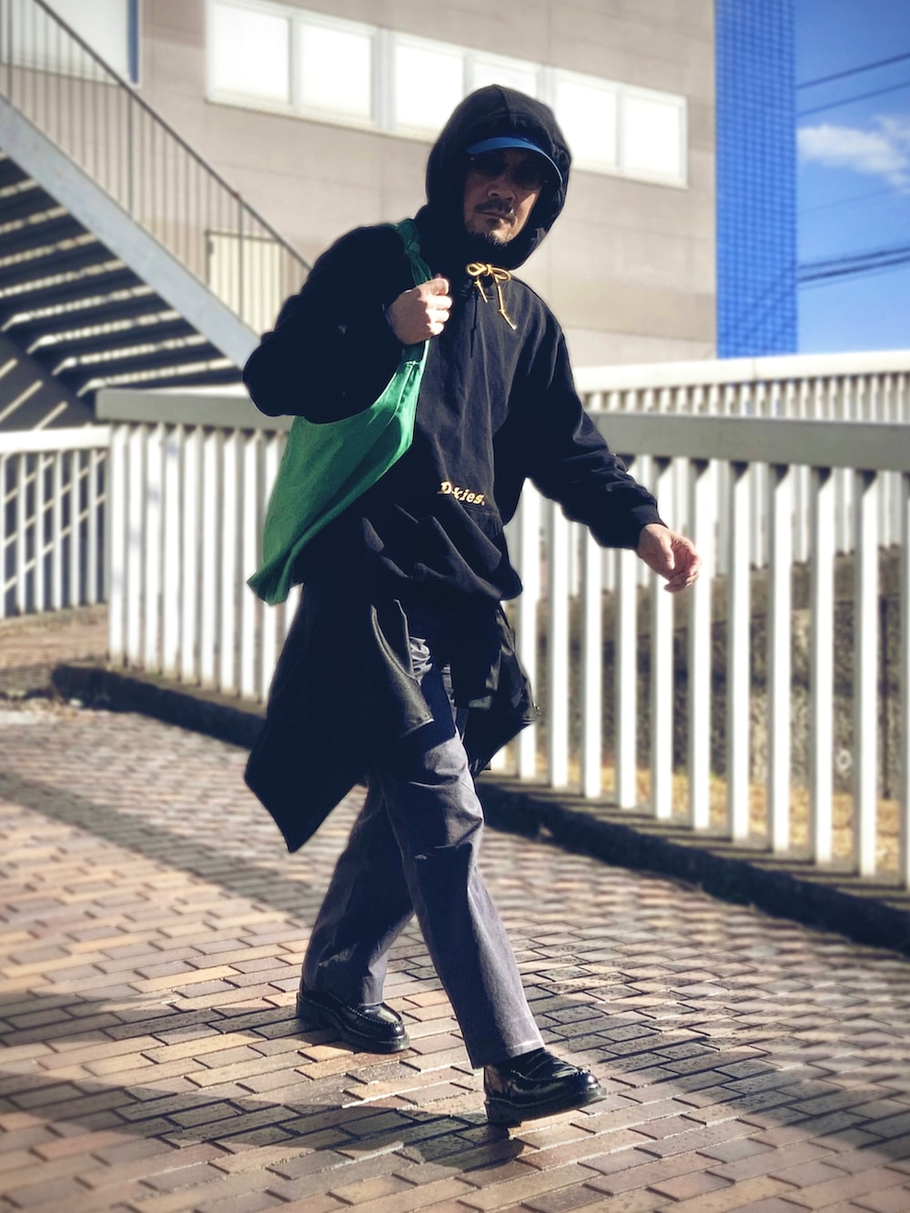 ブラック系のパーカー、ブラック系のジャケット/アウター、グレー系のスラックスを着用したメンズの冬コーディネートの3枚目の写真