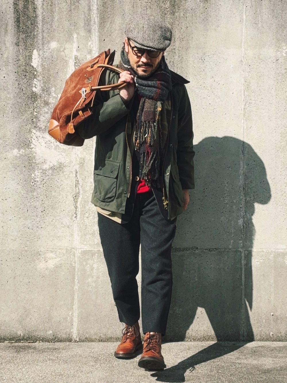 グリーン系のその他アウター、ブラウン系のブーツ、レッド系のニット/セーターを着用したメンズの冬コーディネートの3枚目の写真