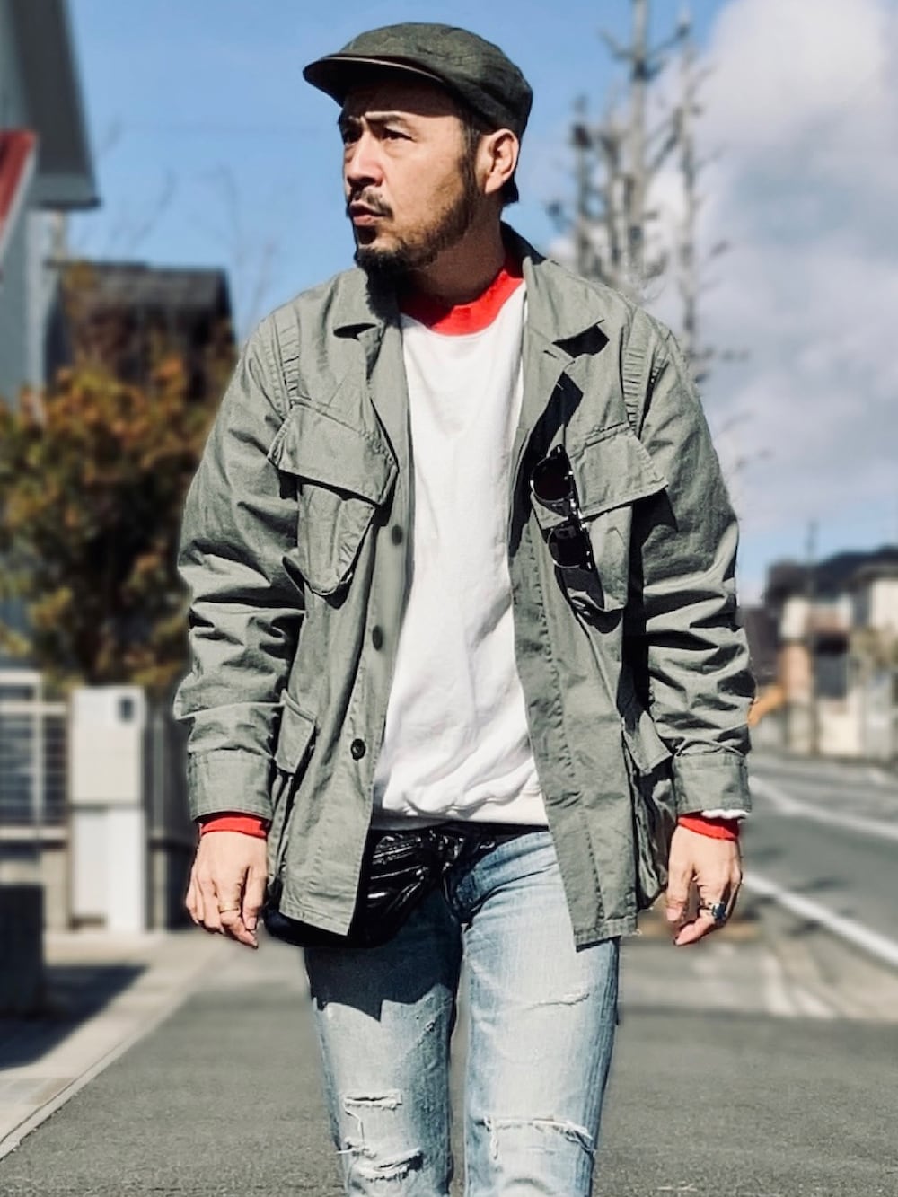 ホワイト系のスウェット、グリーン系のミリタリージャケット、ブルー系のデニムパンツを着用したメンズの冬コーディネートの3枚目の写真