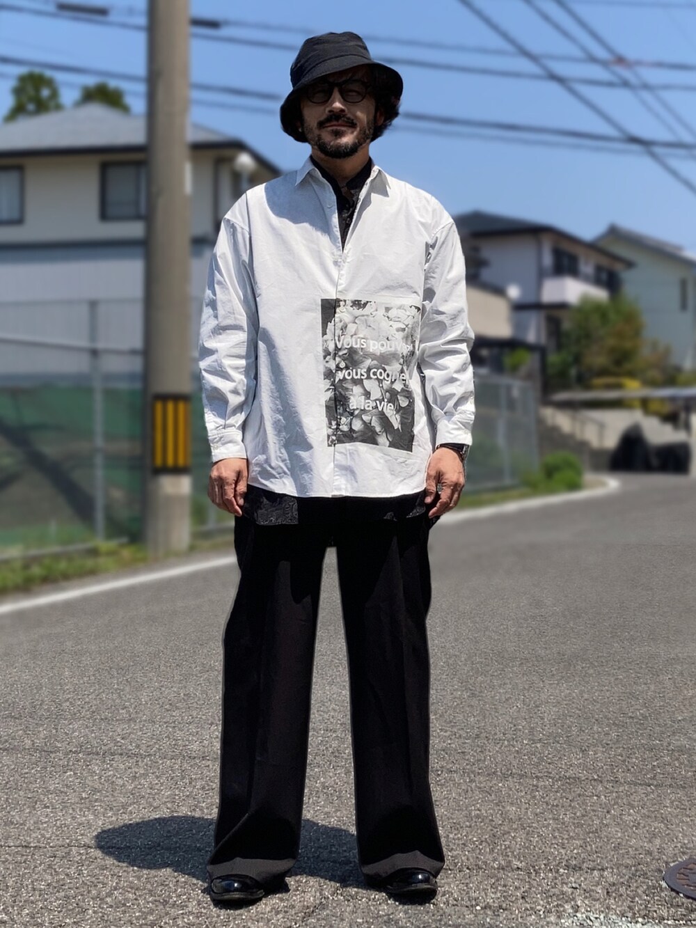 ホワイト系のシャツ/ブラウス、ブラック系のスラックス、ブラック系のブーツを着用したメンズの春コーディネートの3枚目の写真